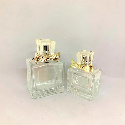 50ml 100mlの絶妙な香水瓶のガラス ビンの合金の弓は空のびんの一致の工場カスタム化に吹きかける